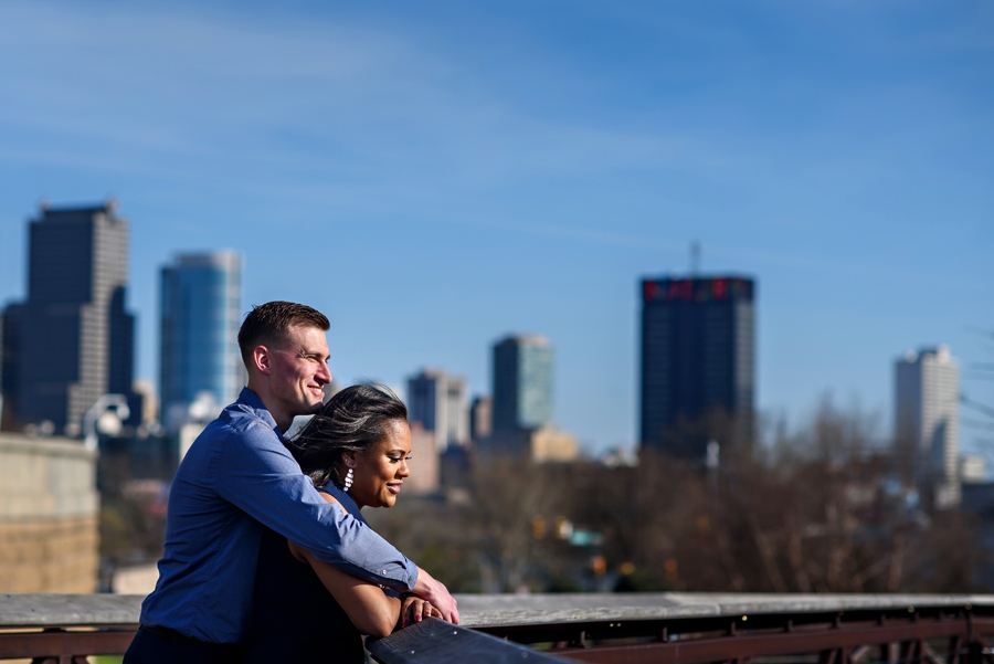 A couple hug and enjoy the view of the city skyline in their Philly Engagement Session.